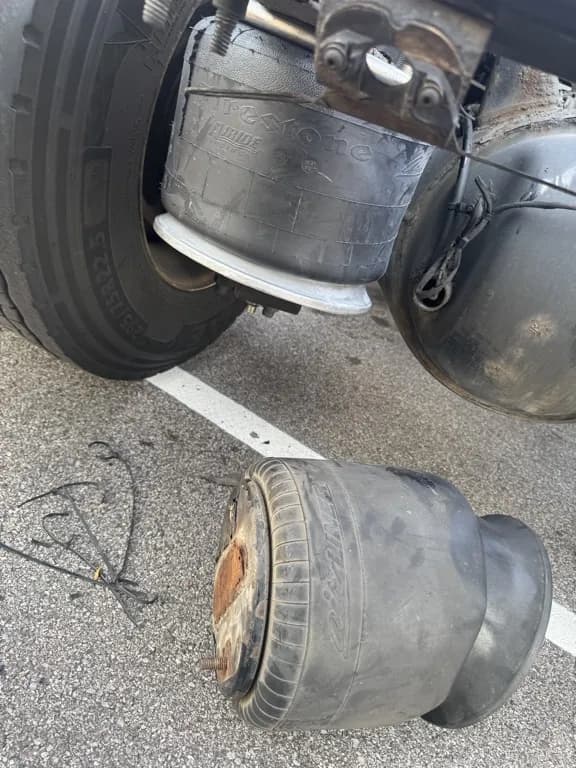 Failed air bag suspension removed with new air bag installed on truck axle