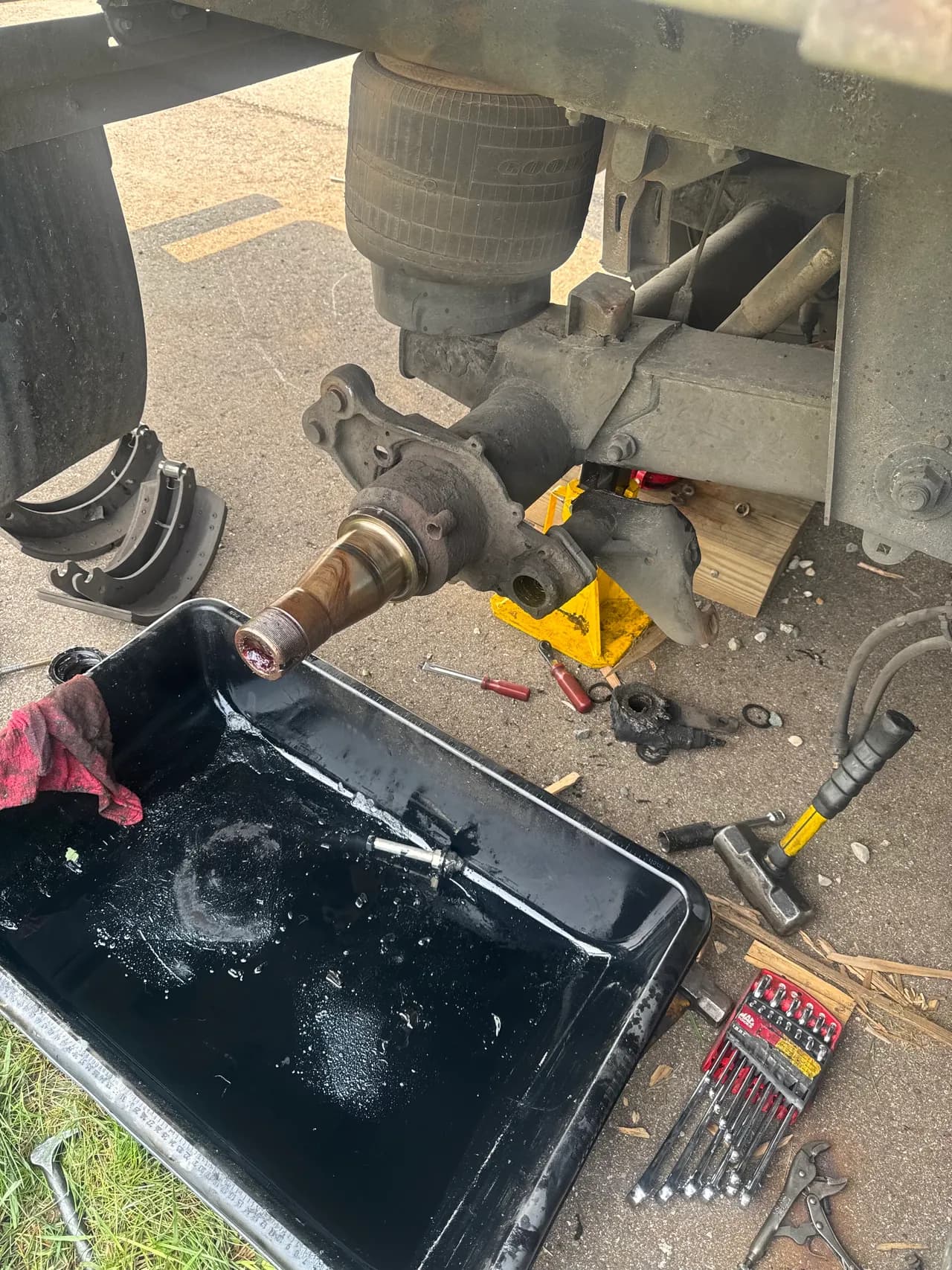 Axle and air bag suspension repair with brake shoes removed and tools laid out