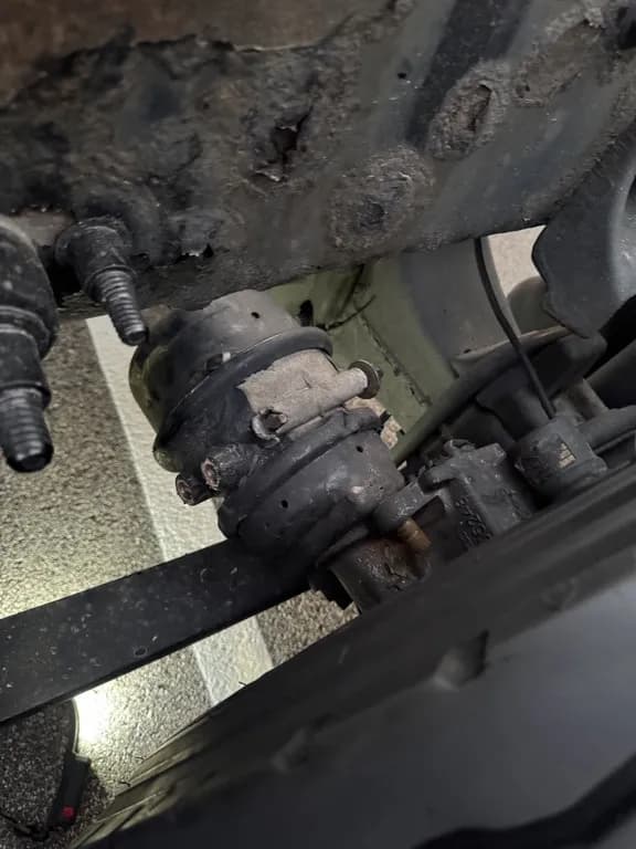 Worn brake chamber on a commercial truck axle before replacement