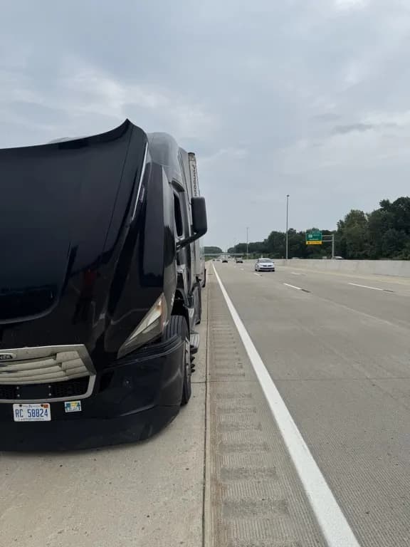 Black semi truck on highway shoulder being serviced by Big Bear Truck Repair